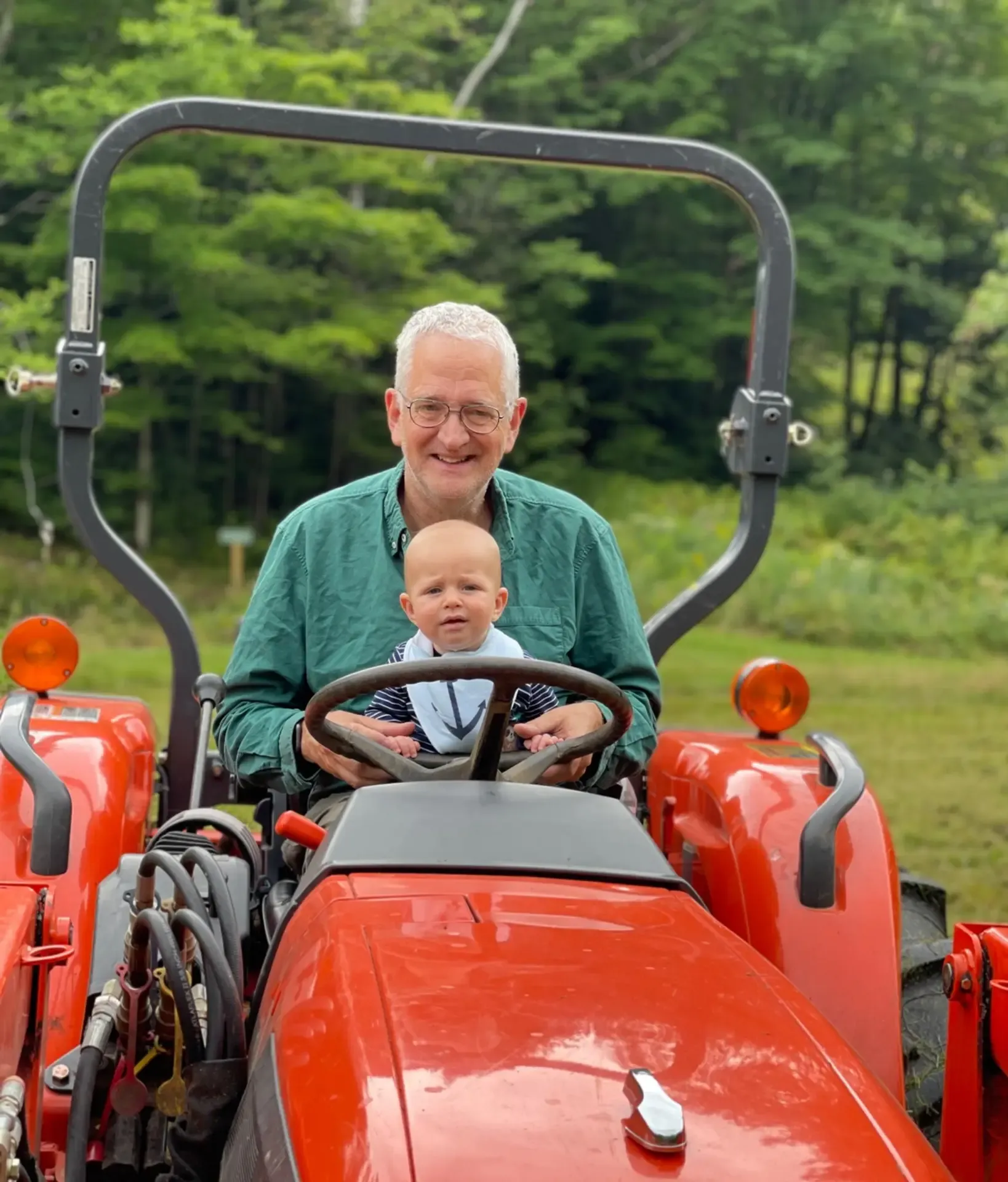 Tim Stout on tractor with grandson
